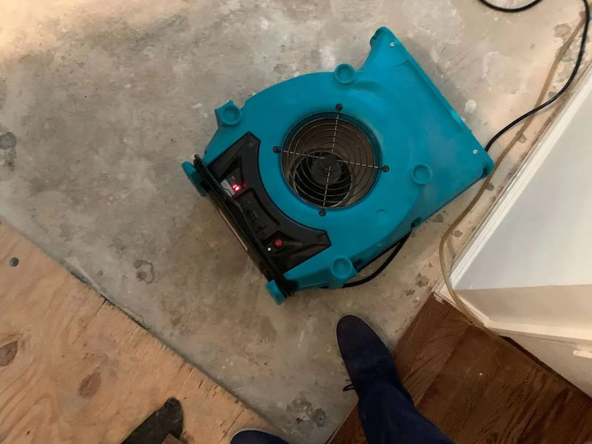 Air mover drying subfloor during Commercial Water Damage Restoration in Attica